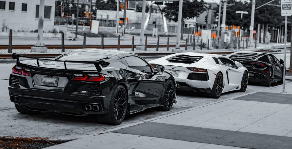 cars, super cars, luxury cars, lamborghini, corvette, black car, white car, sports cars, exotic cars, daytime, parked cars, car row, black lamborghini, white lamborghini, black corvette, high-end vehicles, automobile, car collection, outdoor